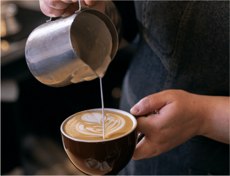 Latte Art Pour Barista pouring milk into a mug to make latte art