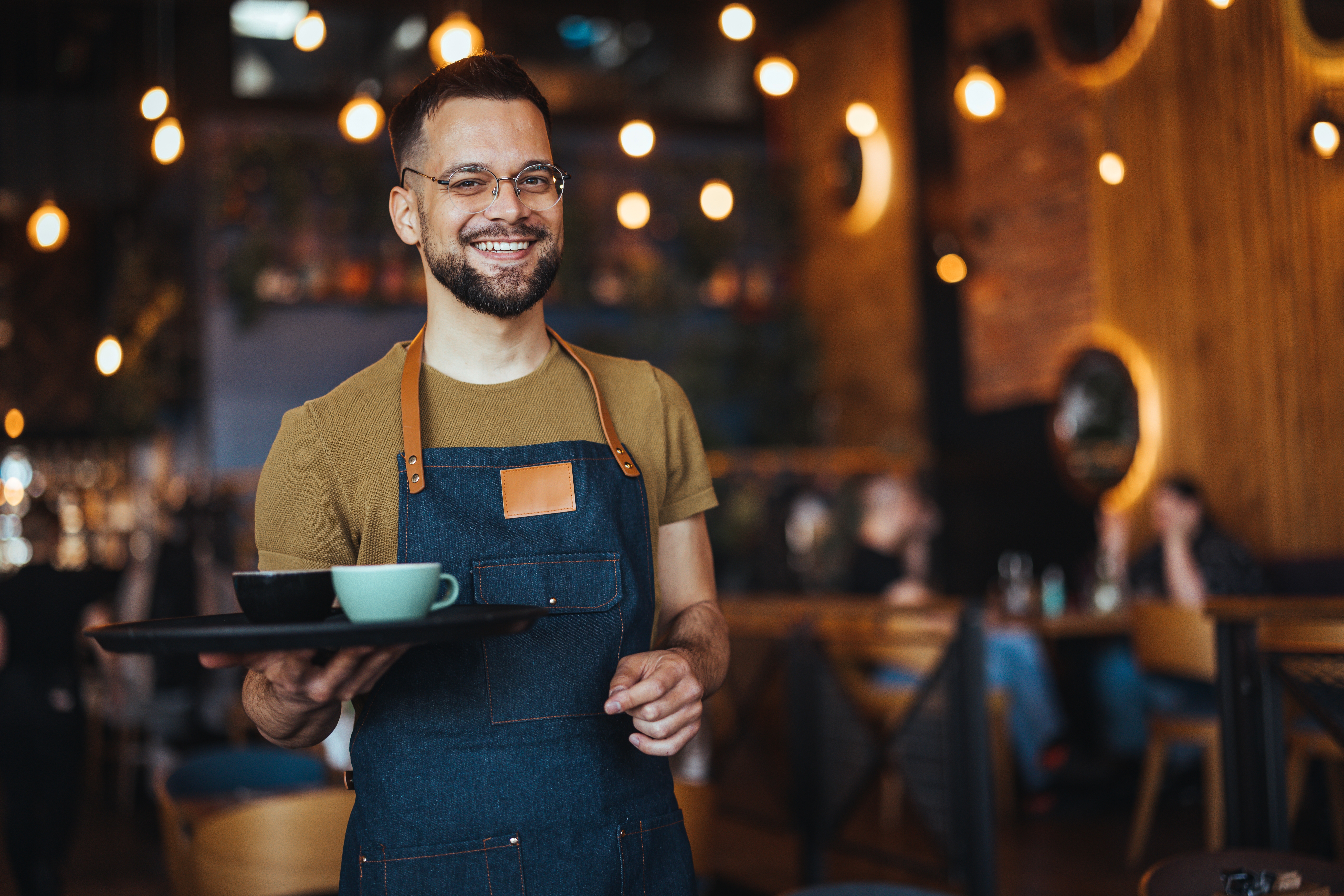Hotel Barista Smiling Holding Coffee Hotel barista delivering coffee, smiling hotel barista, hotel café